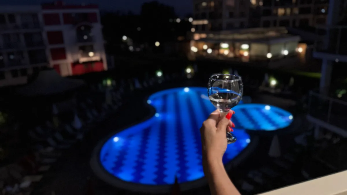 Balcony with champagne overlooking pool at night
